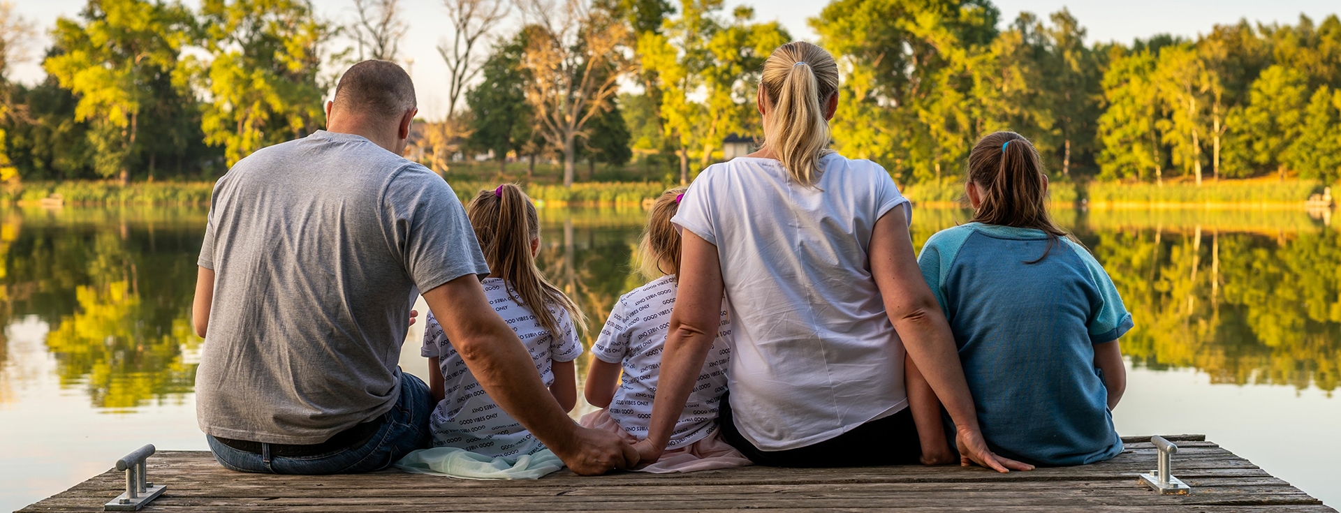 family sitting on a dock